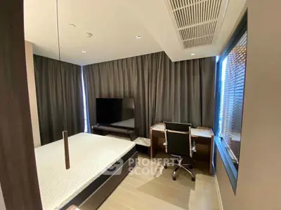 Modern bedroom with sleek design, featuring a large TV, desk, and stylish furnishings.
