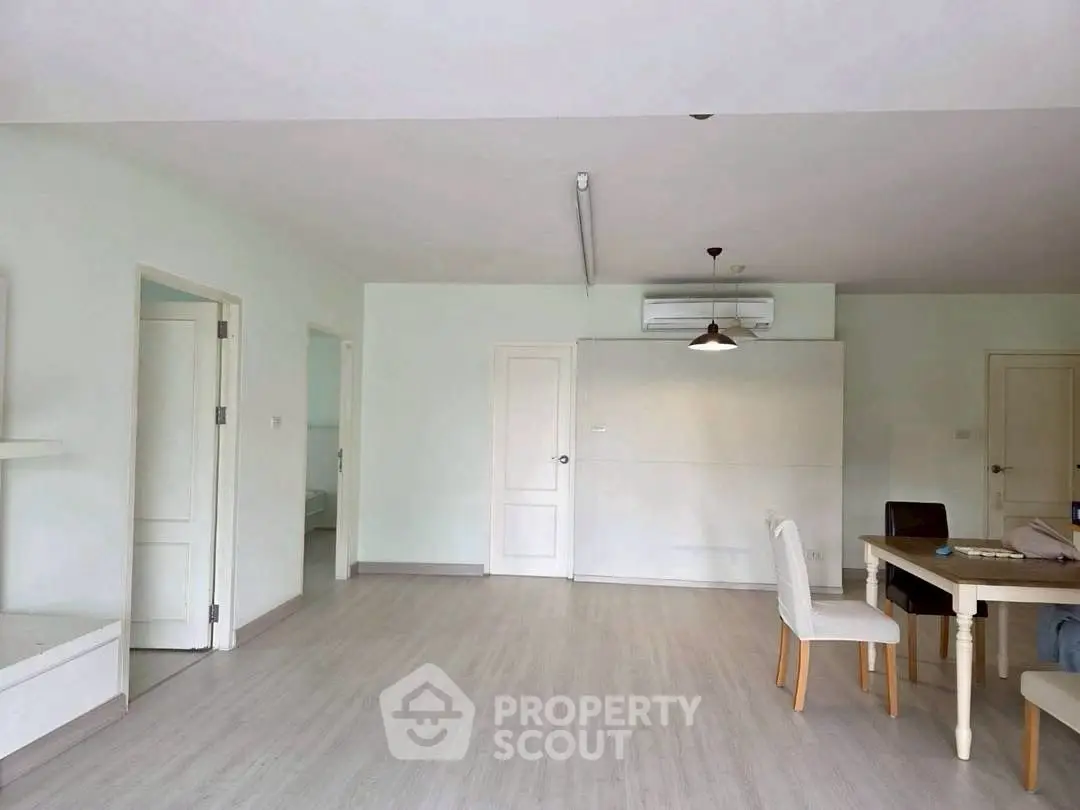 Spacious open-plan living area with modern dining setup and air conditioning.