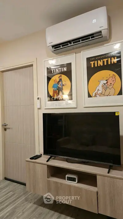 Modern living room with air conditioning and stylish Tintin artwork above TV unit.
