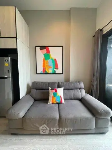Modern living room with stylish gray sofa and colorful abstract art