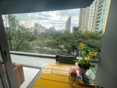 Spacious balcony with stunning city view and lush greenery, perfect for relaxation and outdoor dining.