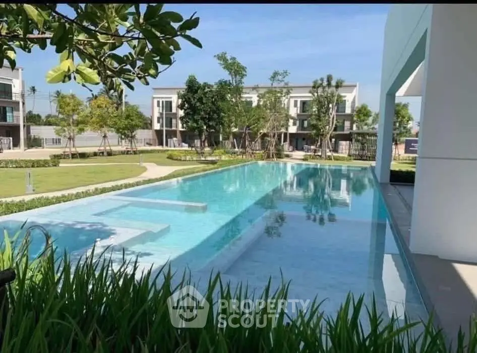 Luxurious residential pool with modern architecture and lush greenery, perfect for relaxation and leisure.