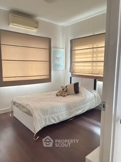 Cozy bedroom with single bed, air conditioning, and stylish window blinds.