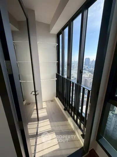 Modern high-rise balcony with stunning city view and sleek glass railing.