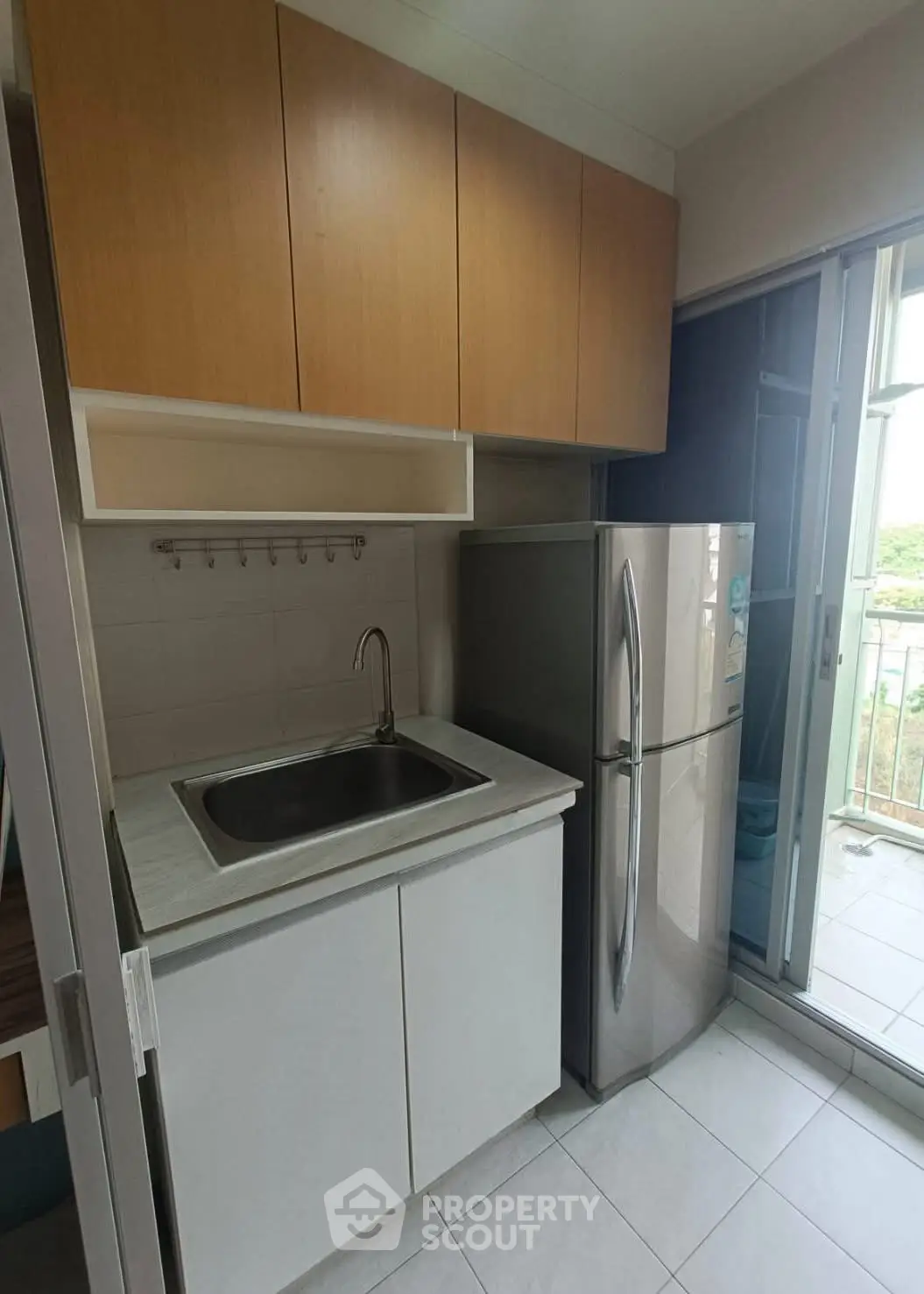 Compact kitchen with modern fridge and balcony view