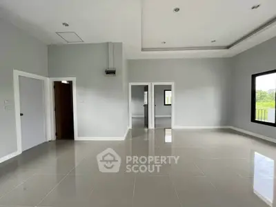 Spacious empty room with large windows and glossy tiled floor, perfect for customization.