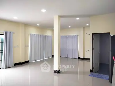 Spacious empty living room with large windows and modern lighting