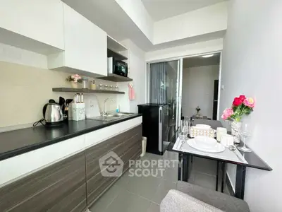 Modern kitchen with sleek cabinetry and dining area in a stylish apartment