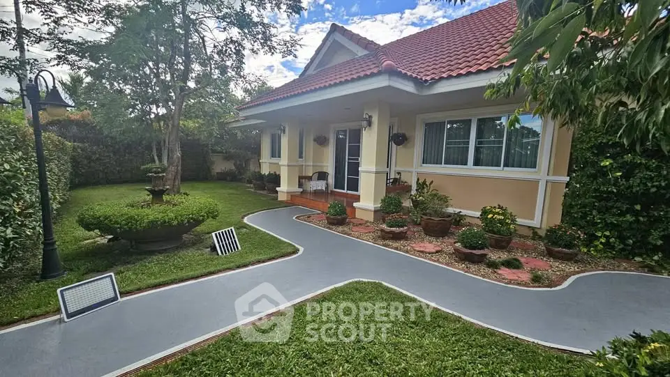 Charming single-story home with red-tiled roof and lush garden pathway