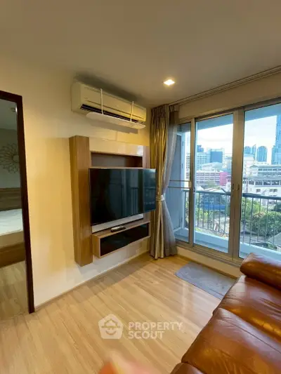 Modern living room with city view, featuring a wall-mounted TV and air conditioning, adjacent to a cozy balcony.