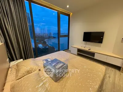 Modern bedroom with large window offering stunning city view, featuring sleek furniture and ambient lighting.