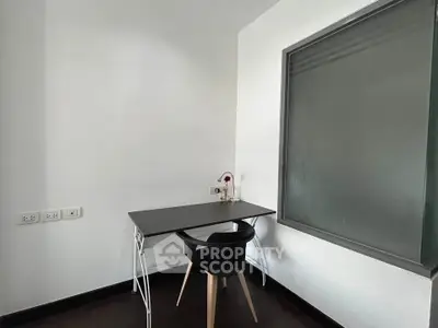 Minimalist study corner with sleek black desk and chair, perfect for productivity in modern home.