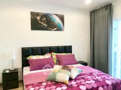 Cozy bedroom with modern decor and vibrant bedding, featuring a stylish wall art piece.