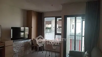 Modern living room with large windows and stylish furniture in a high-rise apartment.