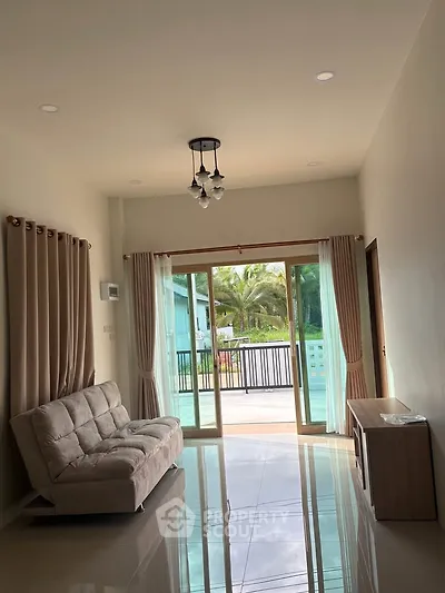 Spacious living room with modern decor and large sliding glass doors leading to a balcony with a scenic view.