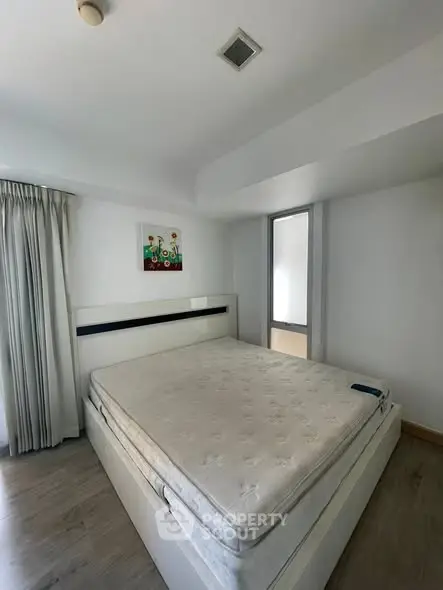 Spacious bedroom with modern decor and natural light