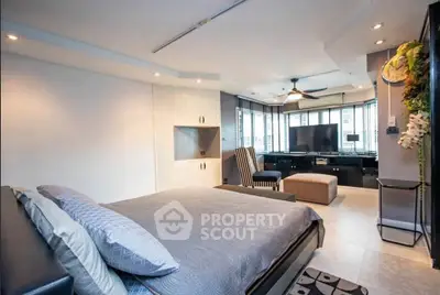 Spacious modern bedroom with stylish decor and large windows for natural light.