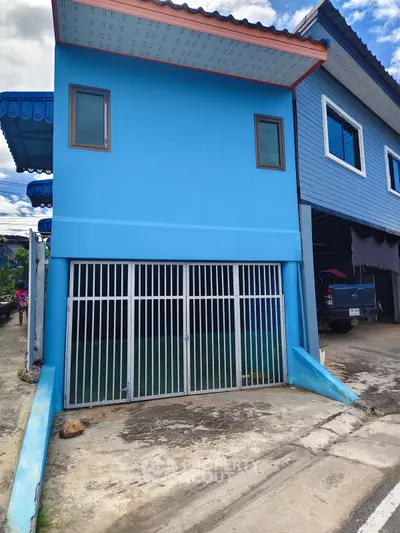 Charming blue two-story house with gated garage in a quiet neighborhood.