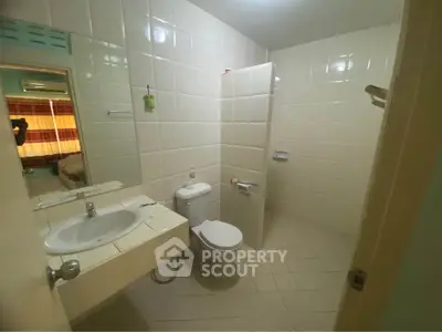 Spacious bathroom with modern fixtures and tiled walls in a cozy apartment.