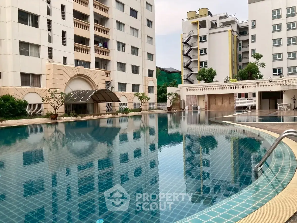 Luxurious apartment complex with a stunning outdoor pool and modern architecture.
