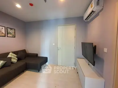 Modern living room with sleek furniture and wall-mounted TV in a cozy apartment.