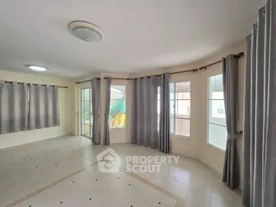 Spacious empty living room with large windows and tiled floor