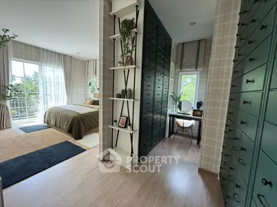 Spacious bedroom with elegant decor and natural light, featuring a cozy study nook and ample storage.