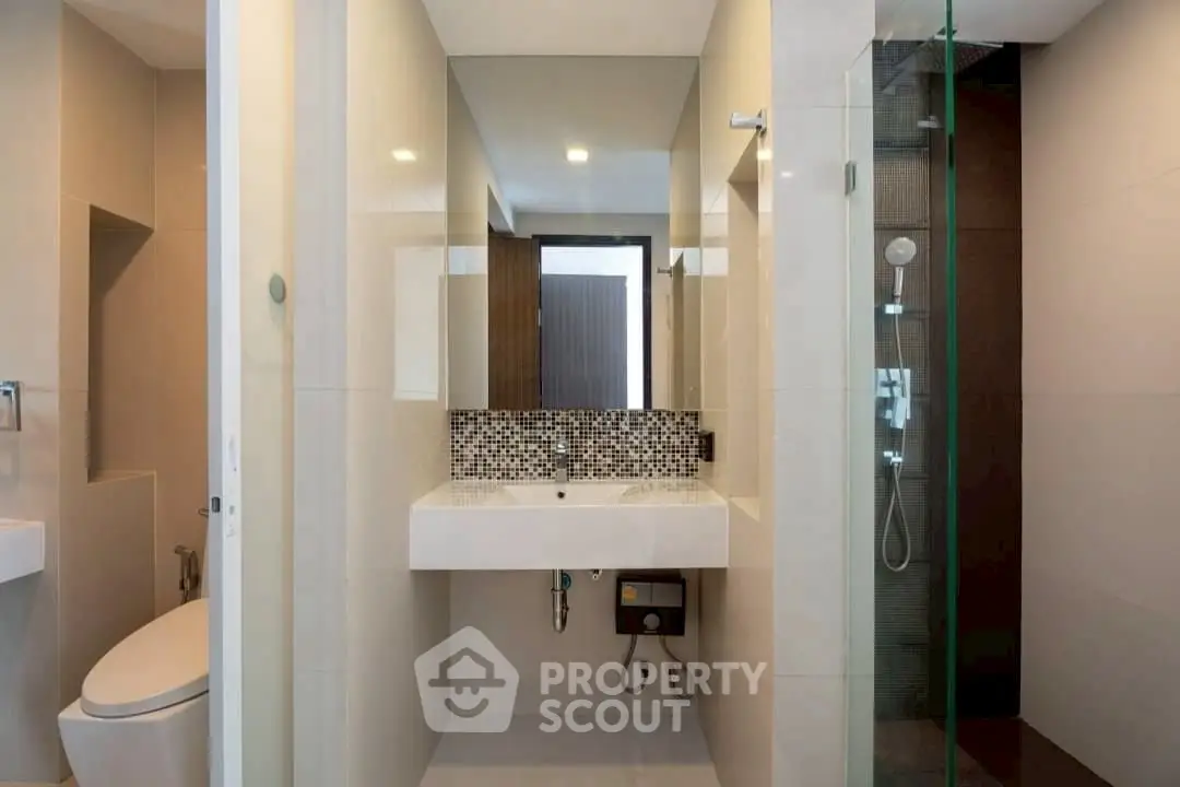 Modern bathroom with sleek design and glass shower enclosure.