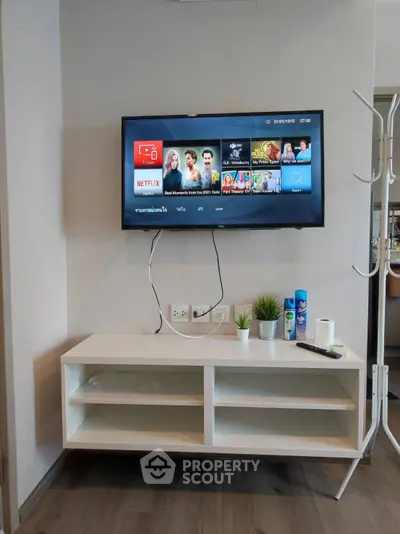 Modern living room with wall-mounted TV and sleek white console, perfect for entertainment and relaxation.