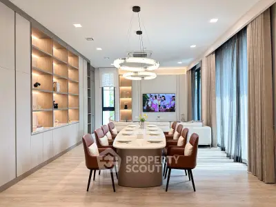 Luxurious dining room with elegant table, leather chairs, and modern lighting in a spacious open layout.