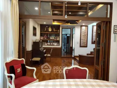 Elegant living room with wooden flooring and stylish decor, featuring a piano and cozy seating area.