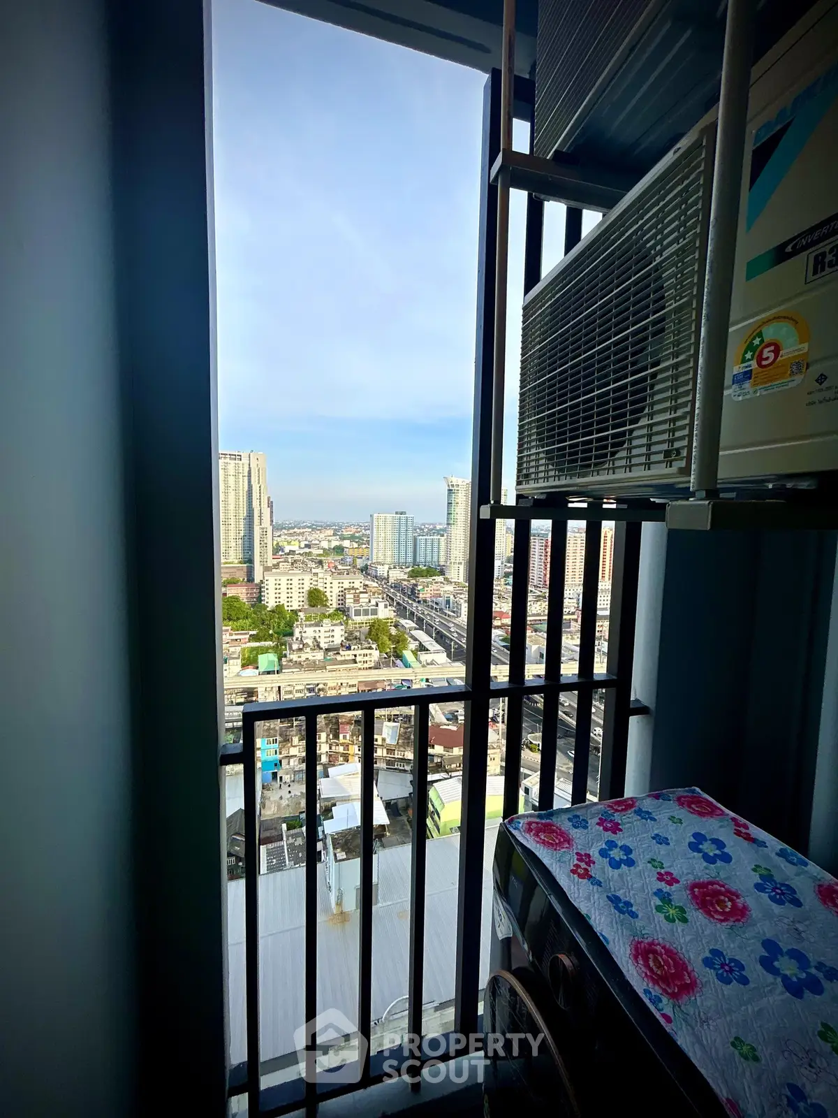 Stunning city view from a high-rise balcony with modern appliances.