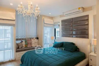 Luxurious bedroom with elegant chandelier and plush bedding in modern apartment