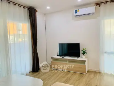 Modern living room with TV, air conditioning, and stylish decor