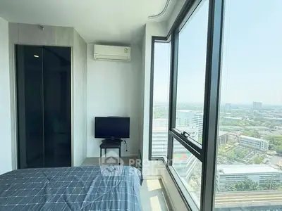 Modern bedroom with large windows offering stunning city views, featuring a sleek design and natural light.