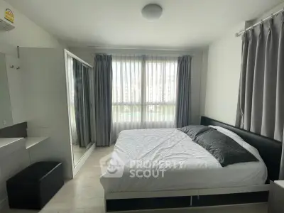 Modern bedroom with large window and stylish decor in a bright apartment.