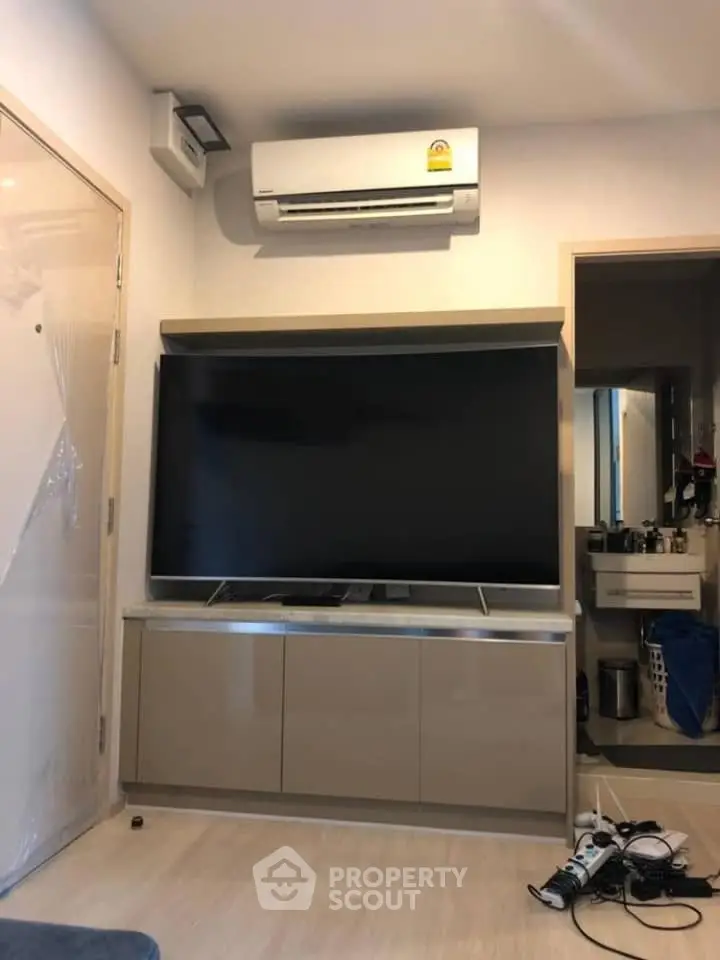 Modern living room with sleek TV setup and air conditioning unit, perfect for comfortable living.