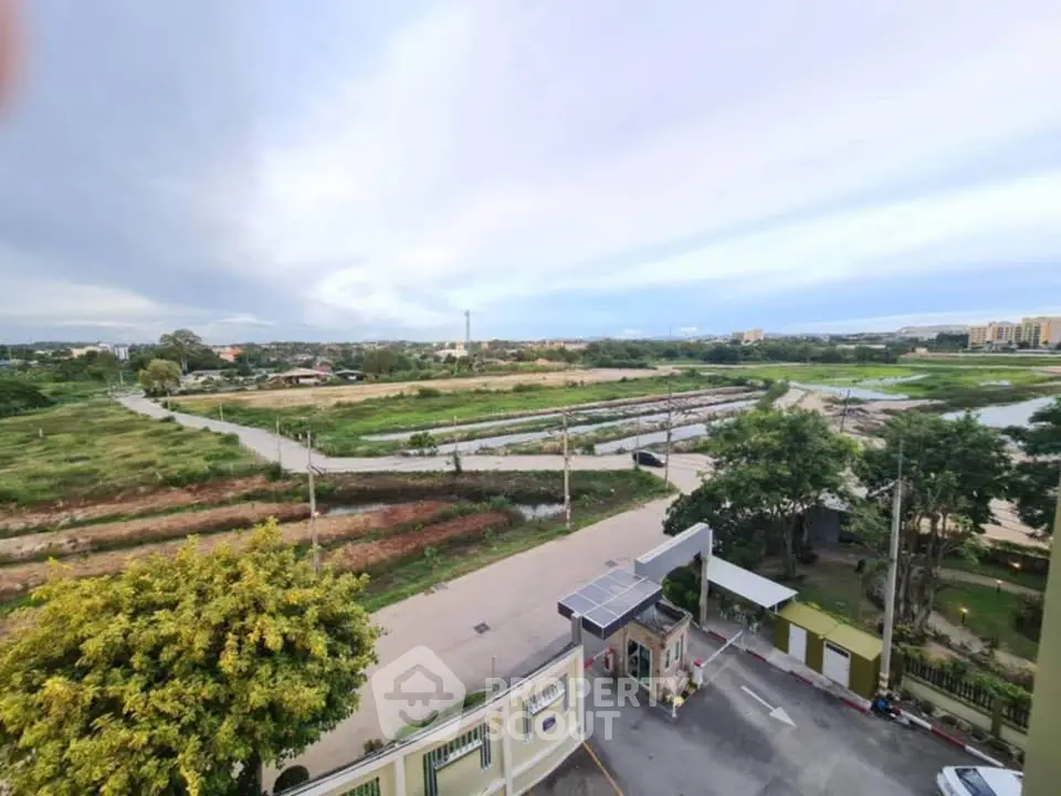 Stunning panoramic view of expansive green fields and distant cityscape from a high vantage point.