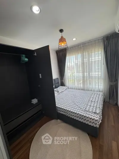 Modern bedroom with stylish decor and ample natural light from large windows.