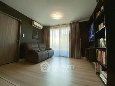 Modern living room with sleek design, featuring a cozy sofa, stylish lighting, and a wall-mounted TV.