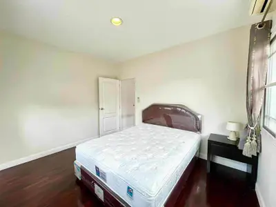 Spacious bedroom with hardwood floors and natural light