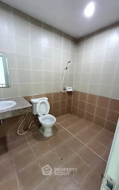 Spacious bathroom with modern fixtures and tiled walls in a real estate property.
