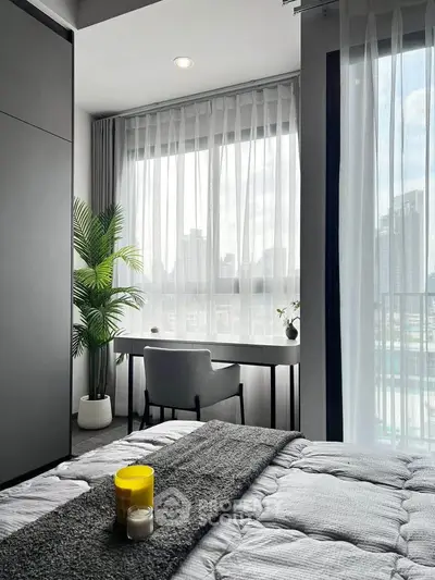 Modern bedroom with city view, featuring a cozy bed, stylish desk, and elegant decor.