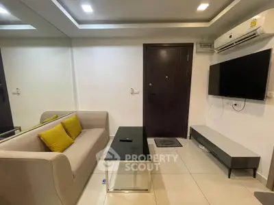 Modern living room with sleek furniture and wall-mounted TV in a stylish apartment.