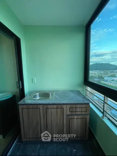 Charming balcony with a small kitchenette and stunning city view, perfect for relaxation and entertaining.