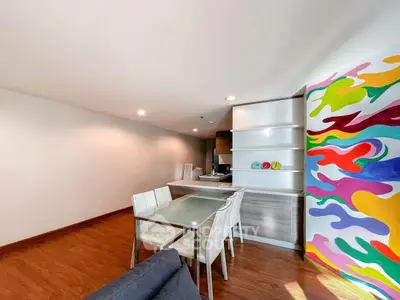 Modern dining area with colorful wall art and sleek kitchen design