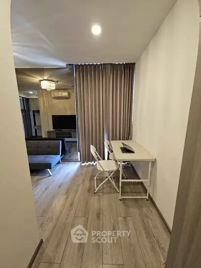 Modern living room with study area, featuring sleek furniture and elegant lighting.