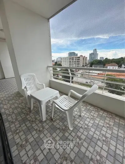 Spacious balcony with city view, perfect for relaxation and outdoor dining.