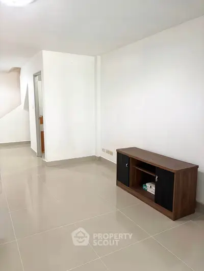 Spacious modern living area with sleek tile flooring and minimalist furniture.