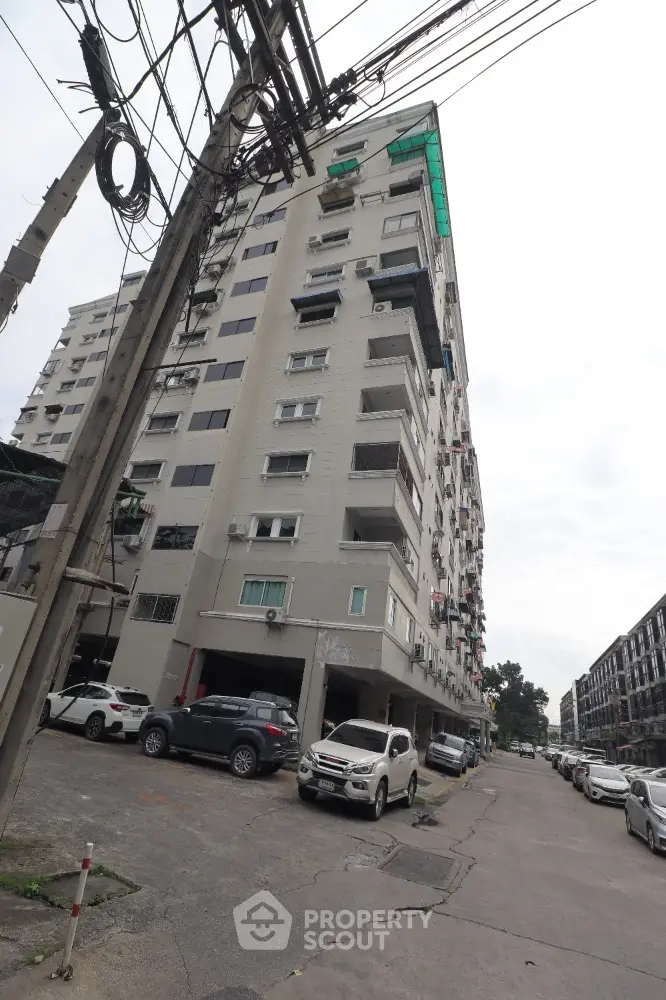 High-rise residential building with parking area and street view